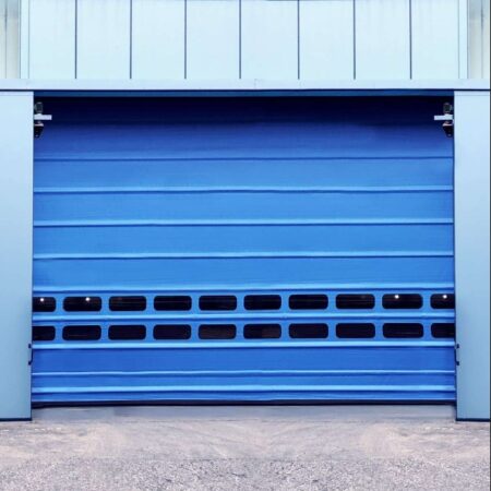 Cortina rápida apilable BMP Pack instalada en acceso industrial, puerta de alta velocidad con estructura reforzada diseñada para tráfico intensivo y control eficiente del ambiente interior.