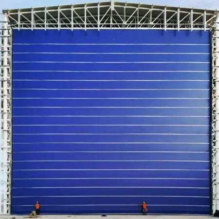 Cortina rápida apilable BMP Mega Pack 200 instalada en acceso industrial de gran tamaño, diseñada para alta resistencia al viento, operación intensiva y control eficiente del tránsito logístico.