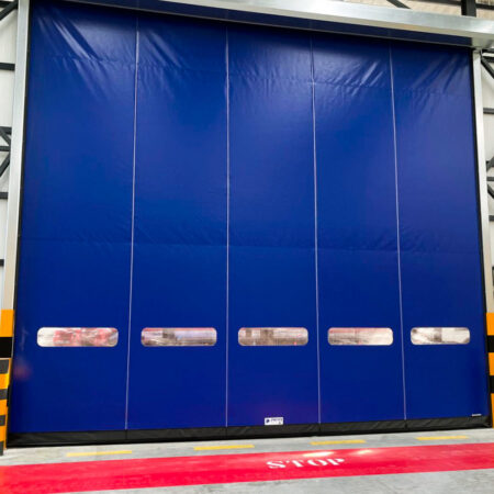 Cortina rápida enrollable BMP DynamicRoll B-Drive instalada en almacén industrial, puerta de alta velocidad diseñada para tráfico intensivo, control ambiental y eficiencia energética.